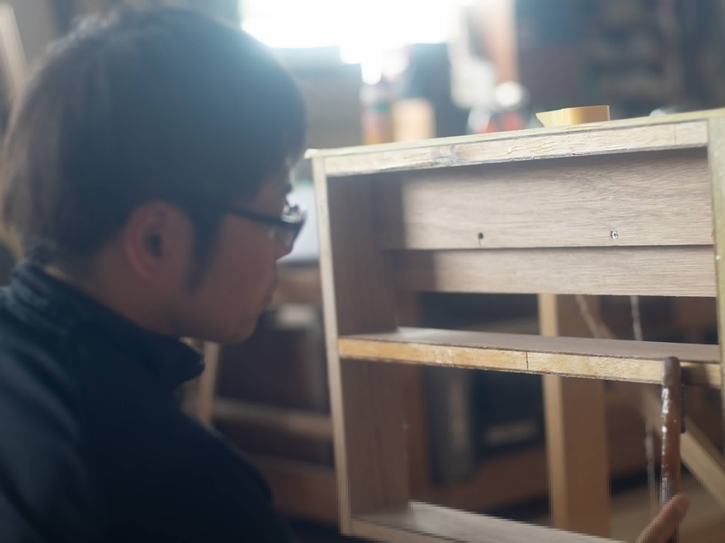 製作中の木製家具の納まりを確認する職人
